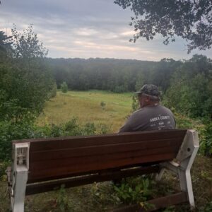 Gene Leibel sitting on first bench placed in Sylvan Park